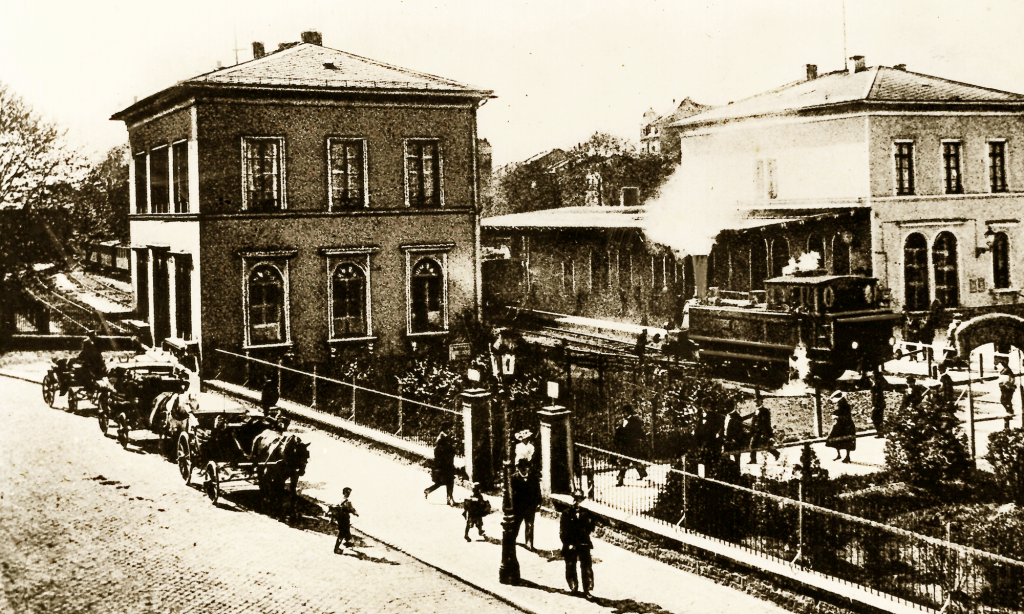 Der historische Lokalbahnhof mit einfahrender Dampflok.
